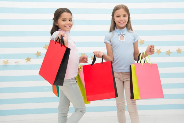 Strávili jsme spolu skvělý čas. Děti spokojené nakupování pruhované pozadí. Posedlý nákupy a obchodem s oblečením. Koncept slevy. Děti roztomilé dívky drží nákupní tašky. Období nákupní slevy — Stock fotografie