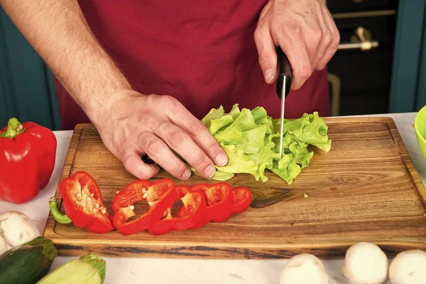 Руки зрізали зелений салат, червоний перець, овочі з ножем — стокове фото