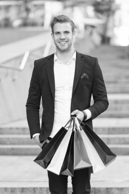 Seçkin alışveriş. Adam alışveriş alışveriş torbaları kentsel arka plan taşır. Başarılı bir iş adamı sadece lüks özel markalar ve yüksek moda butiklerinde alışveriş tercih. Butik Galeri istemci