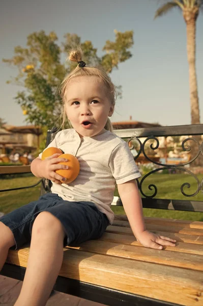 Hayran çocuk ile iki portakal bankta oturan — Stok fotoğraf