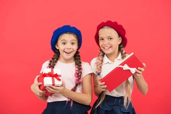 Noi amiamo il Natale. Piccole ragazze carine ricevuto regali di festa. Migliori giocattoli e regali di Natale. Bambini sorelline tenere scatole regali sfondo rosso. I bambini amici entusiasti di disfare i loro regali — Foto Stock