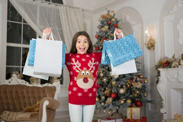 Girl with shopping bags. Happy new year. Christmas. Kid enjoy the holiday. small happy girl at christmas. morning before Xmas. New year holiday. little child girl likes xmas present. christmas party — Stock Photo, Image