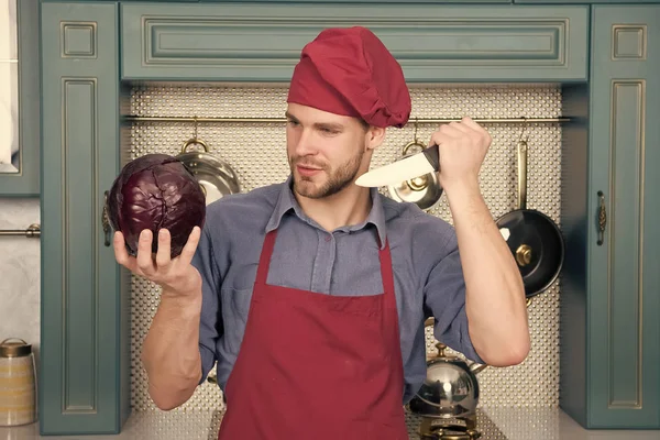 붉은 모자를 쓴 남자 요리사 자주색 양배추와 칼을 들고 있다 — 스톡 사진