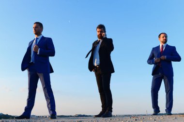 Takım elbiseli, kendine güvenen iş adamları.