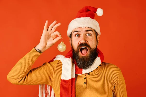 Santa Claus drží zlatý míč pro jedle na červené — Stock fotografie