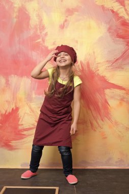 Gülümseyen kız aşçı Şef şapka ve önlük soyut renkli duvar poz. Çocuk ve çocukluk. Pişirme kavramı.