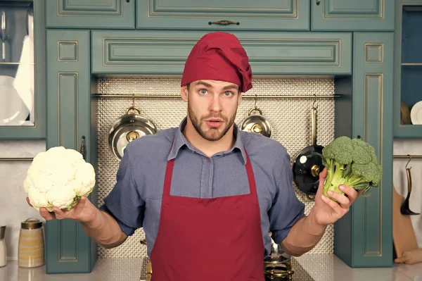 Шеф-кухар Мачо з здивованим обличчям тримає цвітну капусту та брокколі — стокове фото