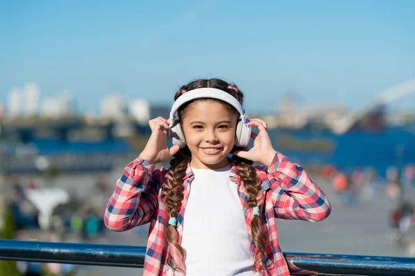 Access to millions of songs. Best music apps that deserve a listen. Girl child listen music outdoors with modern headphones. Listen for free. Stream music anywhere. Get music family subscription