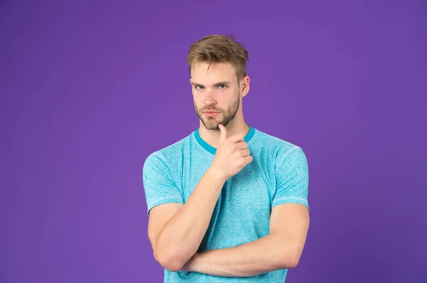 What is on his mind. Man with strong muscular arms. Does having muscular body make you more confident. Man muscular handsome unshaven thoughtful guy on violet background. Masculinity concept
