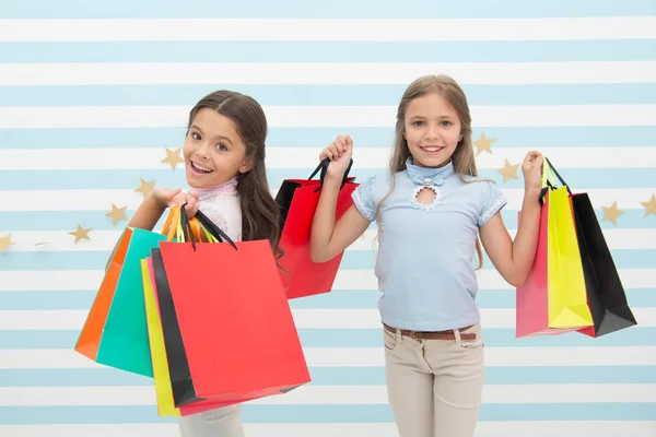 孩子们满意购物条纹的背景。痴迷于购物和服装商场。折扣概念。可爱的孩子们拿着购物袋。购物折扣季节。一起度过美好时光 — 图库照片