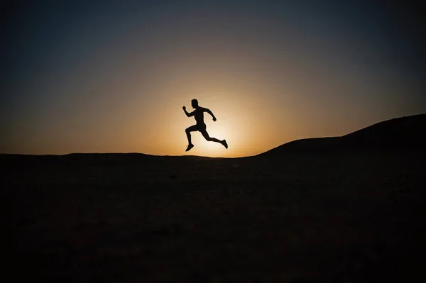 Correndo silhueta homem no céu por do sol — Fotografia de Stock