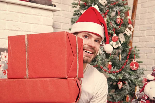 Macho w czerwony kapelusz uśmiech z zapakowane prezenty — Zdjęcie stockowe