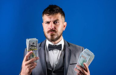 Kolay nakit krediler. Resmi takım elbise mavi arka plan doları banknot yığını tutun. İşadamı nakit para var. Zenginlik ve refah kavramı. Nakit kolay ve hızlı bir şekilde olsun. Nakit işlem iş