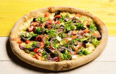 Domatesli pizza, peynir, salata ve kırmızı soğan.
