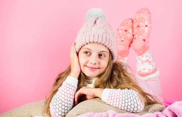 Vinter modeaccessoar. Kid flicka bära söt stickad fashionabla mössa och halsduk tillbehör. Vinter tillbehör koncept. Flicka långt hår dröm rosa bakgrund. Kid drömmande ansikte bär stickad tillbehör — Stockfoto