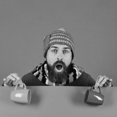 Sakallı ve şaşkın yüzlü hippi çay ya da kahve içer.