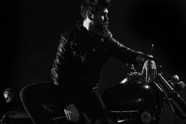Vahşet ve eril kavramı. Sakallı, bisikletçinin yalın motorlu bisiklet karanlıkta siyah arka plan üzerinde deri ceketli adam. Maço, vahşi Motorcu deri ceketli stand motosiklet gece
