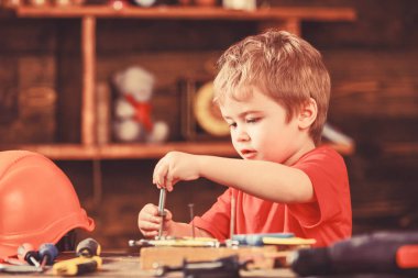 Yürümeye başlayan çocuk meşgul yüzündeki evde atölyede civata ile oynuyor. Çocuk Çocuk tamirci oynamak. Kavram handcrafting. Çocuk şirin ve sevimli ile oynarken Oluşturucusu'nu veya repairer, onarımı veya handcrafting cıvata