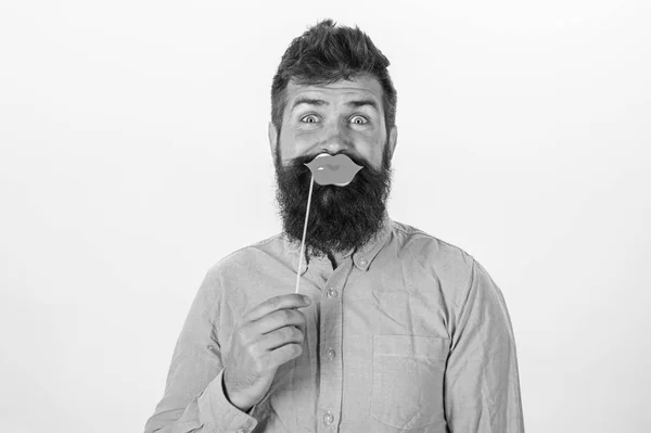 Hipster en chemise rose avec une barbe élégante tenant des lèvres en papier isolées sur fond blanc. Fête d'anniversaire du bel homme barbu, concept de célébration. Homme barbu avec regard surpris levant les sourcils — Photo