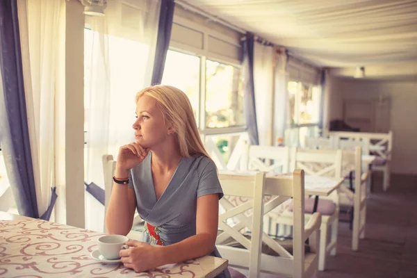 A lány kávét vagy teát iszik kávézóban vagy étteremben.. — Stock Fotó