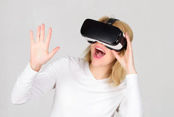 Mulher vestindo óculos de realidade virtual em fundo cinza. Mulher usando fone de ouvido de realidade virtual. Jovem confiante ajustando seu fone de ouvido de realidade virtual e sorrindo. Mulher com RV . — Fotografia de Stock
