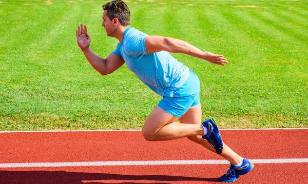 Corredor capturado em movimento logo após o início da corrida. Corrida de sprint de corredor no estádio. Aumentar o conceito de velocidade. Homem atleta corredor empurrar fora posição inicial estádio caminho dia ensolarado. Como começar a correr — Fotografia de Stock