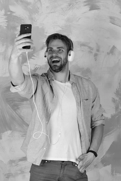 European guy have fun time. Cheerful teenage dj listening songs via earphones. Blue eyed stylish hipster with smartphone. American handsome bearded guy with headphones. Musical lifestyle — Stock Photo, Image