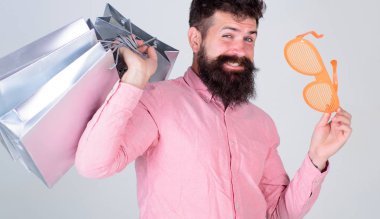 Adam kaygısız tutun alışveriş torbaları sakallı. Alışveriş aptal para harcıyorsun. Aptalca şeyler para ile yapmak. Nasıl ihtiyacın yok şeyler almayı durdurmak için. Alışveriş ile takıntılı. Bağımlısı tüketici kavramı