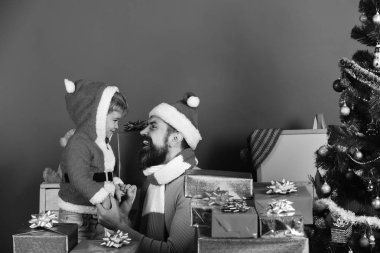 Noel Baba ve küçük asistan köknar ağacının yanındaki hediye kutularının arasında.