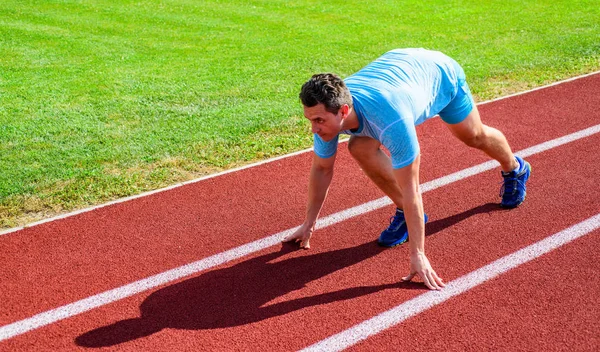 Sport tips from professional runner. Man athlete runner stand low start position stadium path. Make effort for victory. Runner ready to go. Adult runner prepare race at stadium. How to start running — Stock Photo, Image