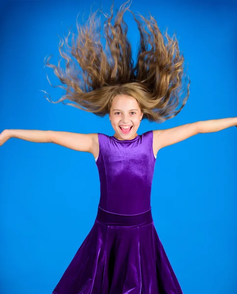 Things you need know about ballroom dance hairstyle. Ballroom latin dance hairstyles. Kid girl with long hair wear dress on blue background. Hairstyle for dancer. How to make tidy hairstyle for kid