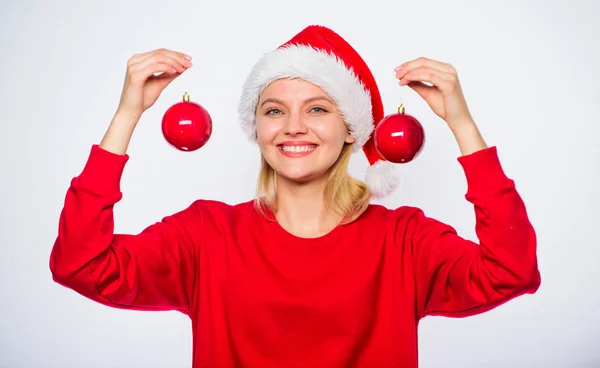 女人戴圣诞老人帽子举行两个球装饰饰品的圣诞节。购买冬季装饰。添加装饰细节假期。新年装饰的概念。冬天是如何装饰的。圣诞树装饰的想法 — 图库照片