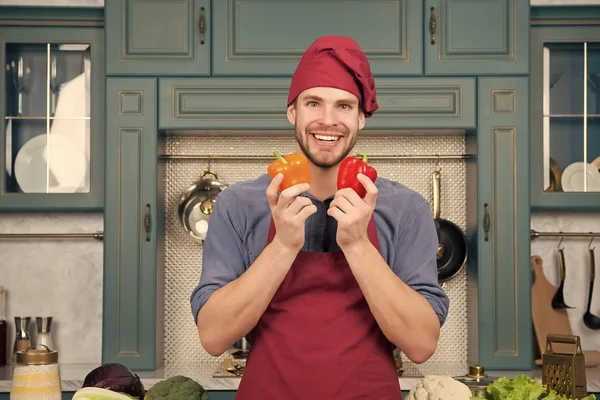 Man in hat glimlach van chef-kok met rode en oranje peper — Stockfoto