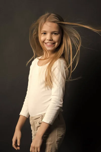 Criança modelo sorrindo com sopro de cabelo longo — Fotografia de Stock