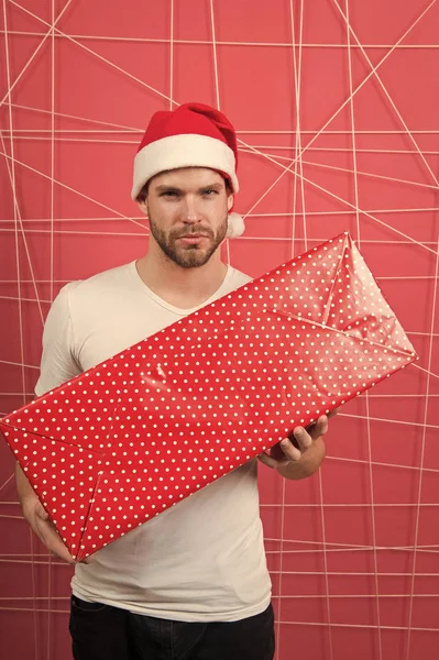 Uomo in cappello di Babbo Natale con scatola lunga su sfondo rosa — Foto Stock