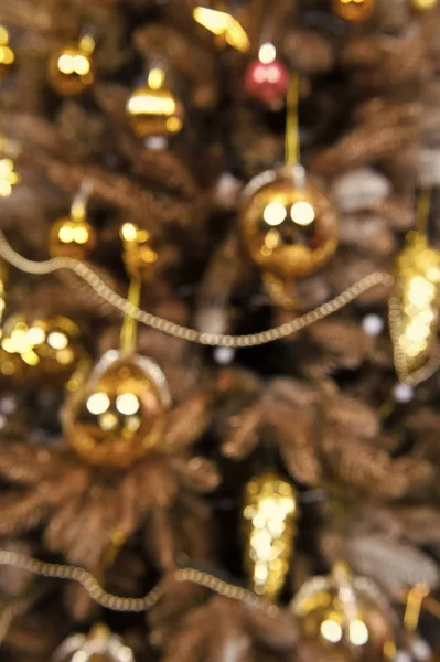 Christmas tree with golden balls, cones, garland on blurred background — Stock Photo, Image