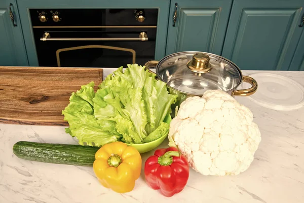 Соус і цвітна капуста, перець, огірок, листя салату на кухонному столі — стокове фото