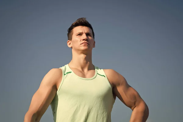 Man bodybuilder poseren op blauwe hemel — Stockfoto