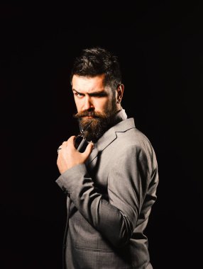 Katı ya da şeytani yüzü olan bir iş adamı siyah arka planda izole edilmiş..