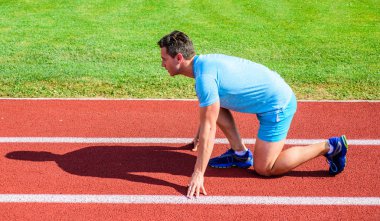 Adam atlet runner standı düşük başlangıç pozisyonu stadyum yolu güneşli bir gün. Runner gitmeye hazır. Zafer için çaba. Spor motivasyon kavramı. Yetişkin runner yarış Stadyumu'nda hazırlayın. Yayınlanmaya başlaması nasıl