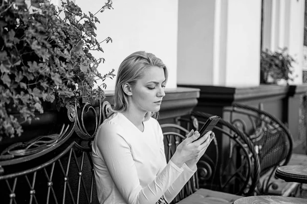 Mantenha-se em contacto. Mulher rosto calmo mensagens smartphone café terraço fundo urbano. Senhora mensagem de texto amigo branco passar o tempo no café. Menina se comunicando com amigo usando smartphone — Fotografia de Stock