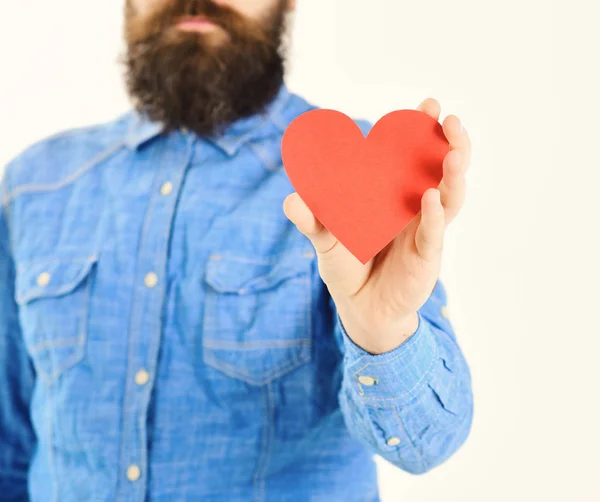 Homem com barba segura coração de papel vermelho na mão, desfocado . — Fotografia de Stock