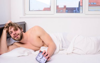 Vücudun saatinizin düzenlenmesi. Adam tıraşsız tousled saç uykusuz yüz dinlenme. Günaydın. Adam tıraşsız yatak tutun çalar saat yatıyordu. Sopa aynı zamanlama zaman uyan yatma vakti. Onun için yeterli uyku