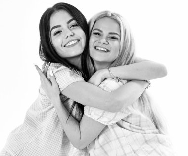 Kızlar sıkı, izole üzerinde beyaz arka plan sarılma. Kız ya da arkadaşlarım pijama. Sarışın ve esmer gülümseyen yüzler uyku giysileri üzerinde şirin ve samimi görünüyor. Kız kardeşim en iyi arkadaş kavramı