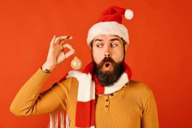 Noel Baba 'nın elinde Noel ağacı süsü var. Sakallı adam