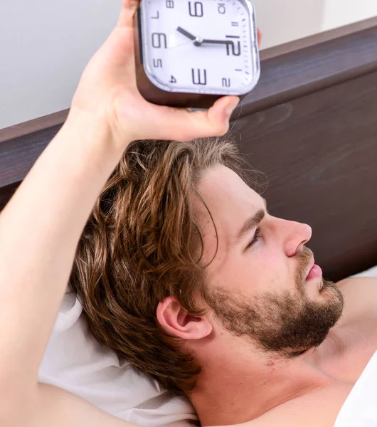 Um jovem acordando na cama e estendendo os braços. O tipo está deitado na cama. Homem de manhã . — Fotografia de Stock