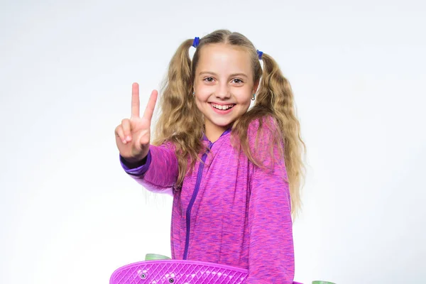 紫のスケート ボードと幸せな小さな女の子。白で隔離ペニー ボードで流行に敏感な子。スポーツとアクティビティ。スケート ボードを楽しんでいます。私はペニーのボードを持っています。乗馬の後の小さな女の子 — ストック写真