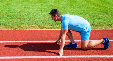 Adam atlet runner standı düşük başlangıç pozisyonu stadyum yolu güneşli bir gün. Zafer için çaba. Runner gitmeye hazır. Yetişkin runner yarış Stadyumu'nda hazırlayın. Nasıl yayınlanmaya başlaması. Spor motivasyon kavramı