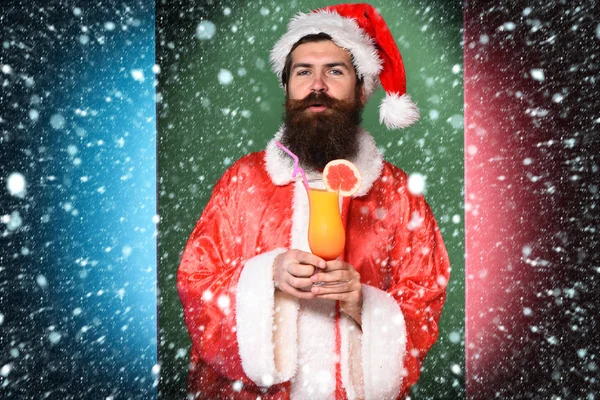 Ciddi yüz alkolsüz kokteyl bardak Noel veya xmas kazak ve yeni yıl şapkası renkli stüdyo arka planda tutarak uzun sakallı yakışıklı Noel Baba adam sakallı — Stok fotoğraf
