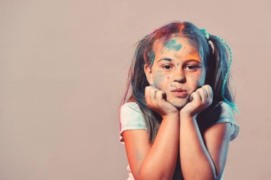 Kız öğrenci yüzündeki boya noktalar var. Çocuk ve yaratıcılık kavramı